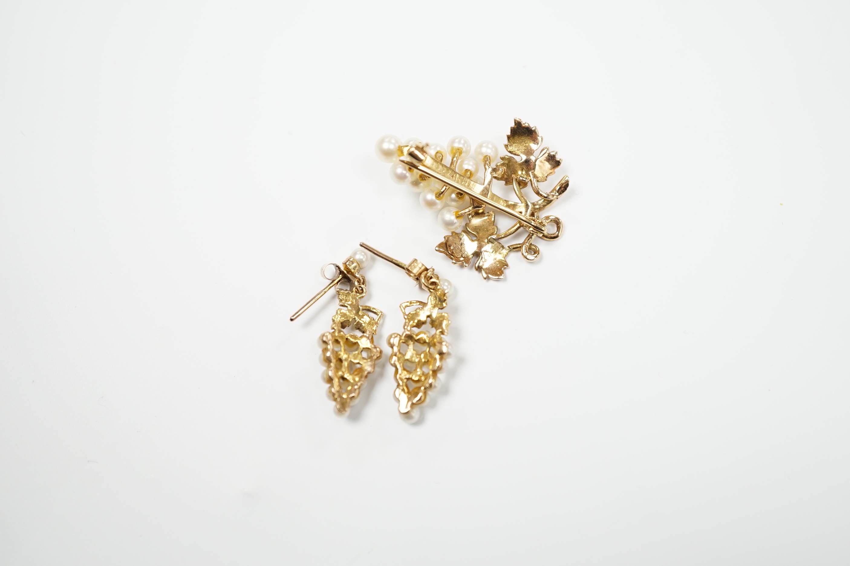 A modern 9ct gold and cultured pearl cluster set suite of jewellery, modelled as a bunch of grapes, comprising a brooch and pair of earrings, gross weight 7.3 grams.